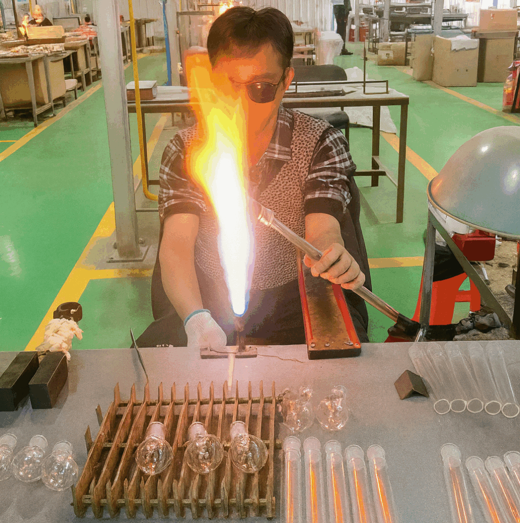 Glassblower shaping borosilicate tubing in a flame to make hand-blown laboratory glassware