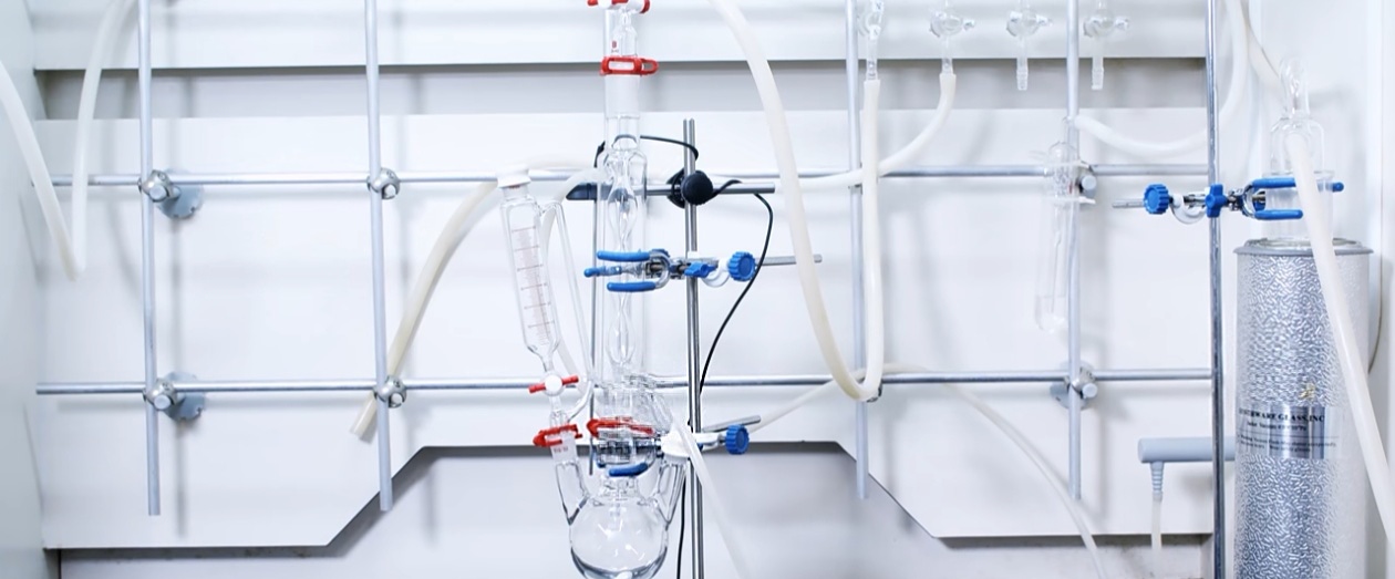 Annotated reflux setup showing flask, condenser, heating source, and support logic in an organic reaction setup